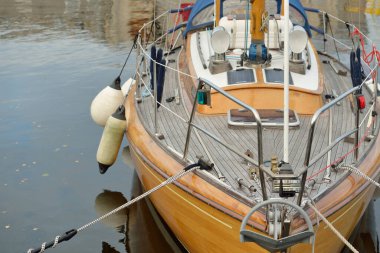 Modern klasik ahşap İsveçli yelkenli teknesi yat limanındaki bir iskeleye demirlemiş. Turizm, tatiller, boş zaman aktiviteleri, eğlence, yelkencilik temaları