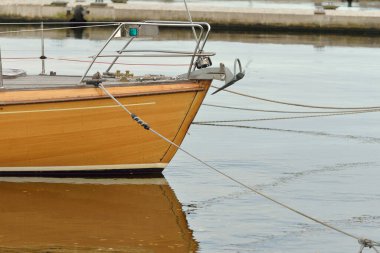 Modern klasik ahşap İsveçli yelkenli teknesi yat limanındaki bir iskeleye demirlemiş. Turizm, tatiller, boş zaman aktiviteleri, eğlence, yelkencilik temaları