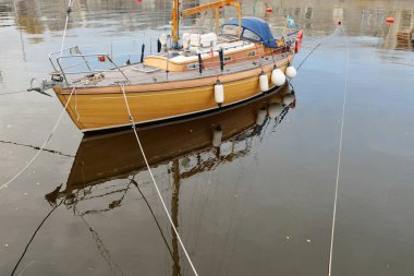 Modern klasik ahşap İsveçli yelkenli teknesi yat limanındaki bir iskeleye demirlemiş. Turizm, tatiller, boş zaman aktiviteleri, eğlence, yelkencilik temaları