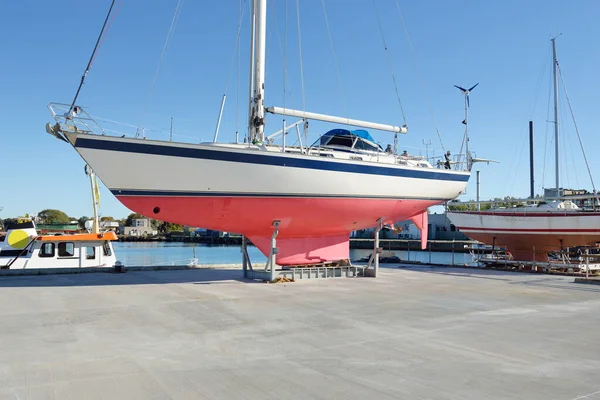 Bir yat limanında karada duran 20 metrelik bir yelkenli. Ulaşım, denizcilik, onarım ve hizmet, yelkencilik, spor, eğlence. Turizm, boş zaman aktivitesi kavramları