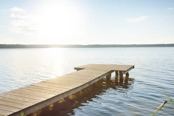 Orman nehri (göl) güneşli bir günde. Ahşap iskele. Clea gökyüzü, kristal berrak suda yansıyor. Idyllic manzara, kırsal manzara. Doğa, ekoloji, eko-turizm, yürüyüş, ekoloji beldesi, yerel turizm