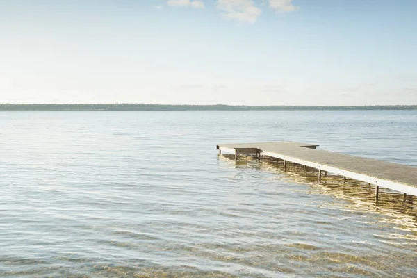 Orman nehri (göl) güneşli bir günde. Ahşap iskele. Clea gökyüzü, kristal berrak suda yansıyor. Idyllic manzara, kırsal manzara. Doğa, ekoloji, eko-turizm, yürüyüş, ekoloji beldesi, yerel turizm