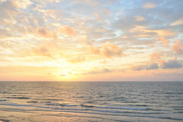 Panoramic view from the Baltic sea shore at sunset. Dramatic cloudscape, glowing clouds, golden sunlight after the storm. Nature, environment, climate change, fickle weather