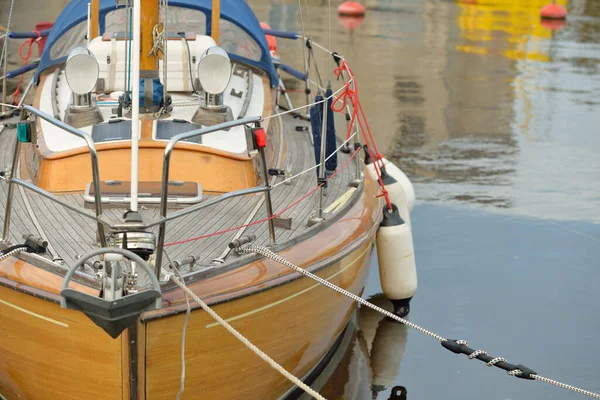 Modern klasik ahşap İsveçli yelkenli teknesi yat limanındaki bir iskeleye demirlemiş. Turizm, tatiller, boş zaman aktiviteleri, eğlence, yelkencilik temaları
