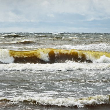 Fırtınadan sonra dramatik günbatımı bulutları altında Baltık Denizi. Dalgalar yakın çekim. Destansı deniz manzarası. Kasırga, fırtına, sert hava, meteoroloji, ekoloji, iklim değişikliği, doğal olaylar
