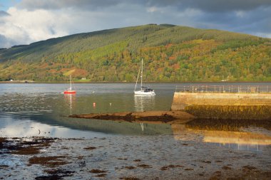 Yelkenli göle demir attı. Görkemli orman tepeleri. İskoçya, İngiltere. Atmosferik manzara. Seyahat yerleri, yelkencilik, seyir, eko turizm, yürüyüş, doğa, çevre koruma