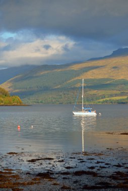 Yelkenli göle demir attı. Görkemli orman tepeleri. İskoçya, İngiltere. Atmosferik manzara. Seyahat yerleri, yelkencilik, seyir, eko turizm, yürüyüş, doğa, çevre koruma