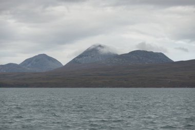 Rocky gölü kıyıları, dağ zirveleri, dağlar, vadiler ve tepeler. Yelkenliden panoramik manzara. Dramatik bir gökyüzü. İskoçya, İngiltere. Atmosferik manzara. Seyahat yerleri, dönüm noktaları, yürüyüş, eko-turizm