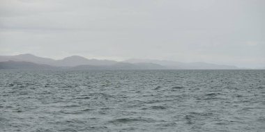 Rocky gölü kıyıları, dağ zirveleri, dağlar, vadiler ve tepeler. Yelkenliden panoramik manzara. Dramatik bir gökyüzü. İskoçya, İngiltere. Atmosferik manzara. Seyahat yerleri, dönüm noktaları, yürüyüş, eko-turizm