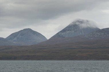 Rocky gölü kıyıları, dağ zirveleri, dağlar, vadiler ve tepeler. Yelkenliden panoramik manzara. Dramatik bir gökyüzü. İskoçya, İngiltere. Atmosferik manzara. Seyahat yerleri, dönüm noktaları, yürüyüş, eko-turizm