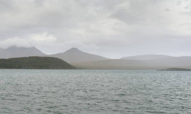 Rocky gölü kıyıları, dağ zirveleri, dağlar, vadiler ve tepeler. Yelkenliden panoramik manzara. Dramatik bir gökyüzü. İskoçya, İngiltere. Atmosferik manzara. Seyahat yerleri, dönüm noktaları, yürüyüş, eko-turizm