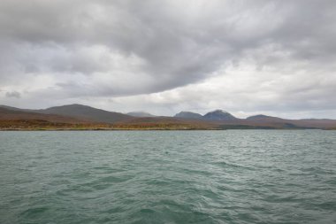 Rocky gölü kıyıları, dağ zirveleri, dağlar, vadiler ve tepeler. Yelkenliden panoramik manzara. Dramatik bir gökyüzü. İskoçya, İngiltere. Atmosferik manzara. Seyahat yerleri, dönüm noktaları, yürüyüş, eko-turizm