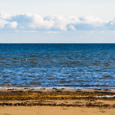 Gün batımında Baltık kıyısı manzarası. Gökyüzü açık. Dalgalar ve su sıçramaları. Idyllic deniz manzarası. Ruhnu Adası, Estonya