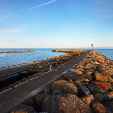 Gün batımında Baltık kıyısı manzarası. Gökyüzü açık. Dalgalar ve su sıçramaları. Idyllic deniz manzarası. Ruhnu Adası, Estonya