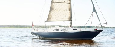 Kumlu kıyıya demirli mavi şalopalı yat (plaj). İsveç 'te, Avrupa' da. Doğa, yaz tatilleri, eğlence, gezi, spor, ulaşım, kiralık özel gemi.