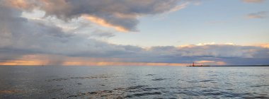 Fırtınadan sonra Baltık Denizi, yelkenli tekneden panoramik manzara. Dramatik gün batımı gökyüzü. Parlayan bulutlar, altın güneş ışığı. Idyllic deniz manzarası. Doğa, gezi, seyahat yerleri