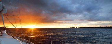 Beyaz yat gün batımında açık denizde yüzüyor. Güverteden pruvaya bir manzara, direk, yelkenler. Destansı bulut manzarası. Fırtınadan sonra parlayan altın bulutlarla dramatik bir gökyüzü. Yarış, spor, eğlence aktivitesi