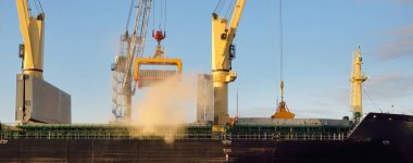 Liman terminalinde vinçleri yükleyen büyük bir yük gemisi (179 metre uzunluğunda). Baltık Denizi. Nakliye, lojistik, küresel iletişim, ekonomi, ticaret, sanayi, arz