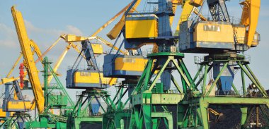 Riga, Letonya 'daki modern kömür terminali. Vinçler yakın plan. Baltık Denizi. Yük taşımacılığı, lojistik, küresel iletişim, ekonomi, ticaret, sanayi, arz, özel ekipman