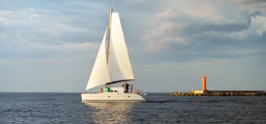 Günbatımında Baltık Denizi 'nde yelkenli yelkenli yelkenli. Fırtınadan sonra açık gökyüzü, yumuşak güneş ışığı. Ulaşım, seyahat, gezi, spor, eğlence, boş zaman aktivitesi, yaşam tarzı, aile
