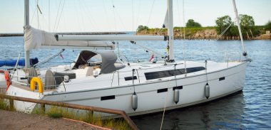 Günbatımında limanda bir rıhtıma demirlenmiş modern beyaz şalopeli yat. Panoramik manzara. Akdeniz 'de. Kiralık, gezici, eğlence, eğlence, eğlence, spor, yelkenli yarışı için özel bir gemi.