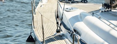 Limandaki bir rıhtıma demirlenmiş modern bir yat. Tahta meşe güvertesi, direği ve yelkenleri yukarıdan görüyor. Akdeniz 'de. Kiralık, gezici, eğlence, eğlence, eğlence, spor, yelkenli yarışı için özel bir gemi.