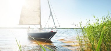 Kumlu kıyıya demirli mavi şalopeli yat (kumsalda otlarla kaplanmış). İsveç 'te, Avrupa' da. Doğa, yaz tatilleri, eğlence, gezi, spor, ulaşım, eko-turizm