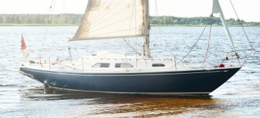 Kumlu kıyıya demirli mavi şalopalı yat (plaj). İsveç 'te, Avrupa' da. Doğa, yaz tatilleri, eğlence, gezi, spor, ulaşım, kiralık özel gemi.