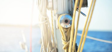 Açık bir günde beyaz yelkenli tekneyle denize açılmak. Güverteden direğe kadar bir manzara. Ekipmanlar, ipler, yakın çekim. Ulaşım, seyahat, gezi, eğlence, eğlence, eğlence, yat yarışı.