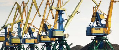 Riga, Letonya 'daki modern kömür terminali. Vinçler yakın plan. Baltık Denizi. Nakliye, lojistik, küresel iletişim, ekonomi, iş, endüstri, tedarik, özel ekipman. Şehir manzarası