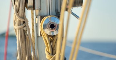 Açık bir günde beyaz yelkenli tekneyle denize açılmak. Güverteden direğe kadar bir manzara. Ekipmanlar, ipler, yakın çekim. Ulaşım, seyahat, gezi, eğlence, eğlence, eğlence, yat yarışı.