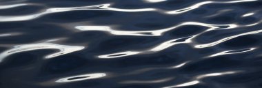 Gün batımında deniz. Karanlık su yüzeyi yakın plan. Soyut doğal desen, doku, arkaplan, duvar kağıdı, grafik kaynaklar, kopyalama alanı, üç boyutlu görüntüleme. Doğa, çevre, turizm, gezi, yüzme konsepti