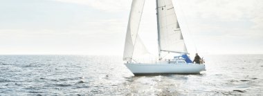 Açık denizde yelkenli yelkenli yelkenli. Gökyüzü açık, bulutlu. Yelkenlinin manzarası. Ulaşım, seyahat, spor, eğlence, boş zaman aktivitesi, yarış, yelkenli yarışı. Panorama, boşluğu kopyala