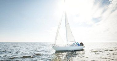 Açık denizde yelkenli yelkenli yelkenli. Gökyüzü açık, bulutlu. Yelkenlinin manzarası. Ulaşım, seyahat, spor, eğlence, boş zaman aktivitesi, yarış, yelkenli yarışı. Panorama, boşluğu kopyala