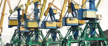 Riga, Letonya 'daki modern kömür terminali. Vinçler yakın plan. Baltık Denizi. Nakliye, lojistik, küresel iletişim, ekonomi, iş, endüstri, tedarik, özel ekipman. Şehir manzarası