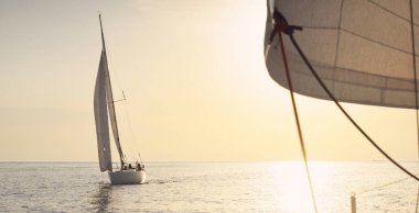 Günbatımında Baltık Denizi 'nde yelkenli yelkenli yelkenli. Fırtınadan sonra gökyüzü açık, altın güneş ışığı. Ulaşım, seyahat, gezi, spor, eğlence, boş zaman aktivitesi, yarış, yelkenli yarışı