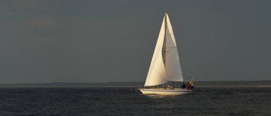 Günbatımında Baltık Denizi 'nde yelkenli yelkenli yelkenli. Fırtınadan sonra açık gökyüzü, yumuşak güneş ışığı. Ulaşım, seyahat, gezi, spor, eğlence, boş zaman aktivitesi, yaşam tarzı, aile