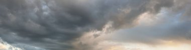 Süslü bulutlar. Dramatik bir gökyüzü. Destansı fırtına bulutları. Yumuşak güneş ışığı. Panoramik görüntü, doku, arkaplan, grafik kaynakları, tasarım, kopyalama alanı. Meteoroloji, cennet, umut, barış kavramı