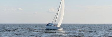 Açık denizde yelkenli yelkenli yelkenli. Gökyüzü açık, bulutlu. Yelkenlinin manzarası. Ulaşım, seyahat, spor, eğlence, boş zaman aktivitesi, yarış, yelkenli yarışı. Panorama, boşluğu kopyala