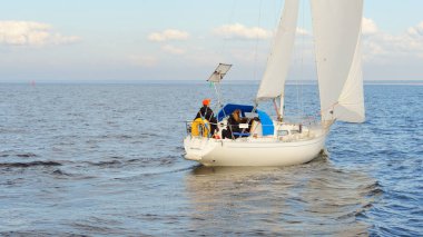 Açık denizde yelkenli yelkenli yelkenli. Gökyüzü açık, bulutlu. Yelkenlinin manzarası. Ulaşım, seyahat, spor, eğlence, boş zaman aktivitesi, yarış, yelkenli yarışı. Panorama, boşluğu kopyala