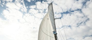 Günbatımında Baltık Denizi 'nde yelkenli yelkenli yelkenli. Kokpitten direğe ve yelkenlere bakın. Dramatik bir gökyüzü. Ulaşım, seyahat, gezi, spor, eğlence, boş zaman aktivitesi, yelkenli yarışı