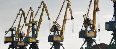 Riga, Letonya 'daki modern kömür terminali. Vinçler yakın plan. Baltık Denizi. Nakliye, lojistik, küresel iletişim, ekonomi, iş, endüstri, tedarik, özel ekipman. Şehir manzarası