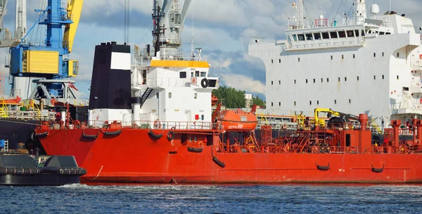 Kargo gemileri iskele terminaline yükleniyor. Vinçler arka planda. Baltık Denizi. Bunkering, akaryakıt ve enerji üretimi, arz, teknoloji, lojistik, hizmet, sanayi, ticaret