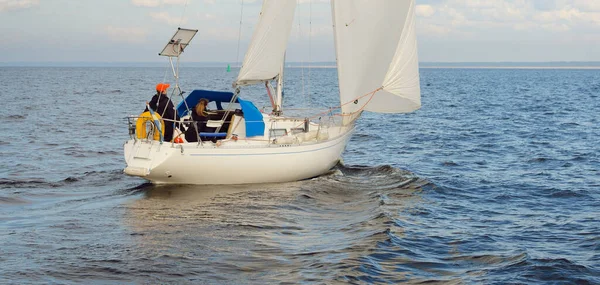 Açık denizde yelkenli yelkenli yelkenli. Gökyüzü açık, bulutlu. Yelkenlinin manzarası. Ulaşım, seyahat, spor, eğlence, boş zaman aktivitesi, yarış, yelkenli yarışı. Panorama, boşluğu kopyala