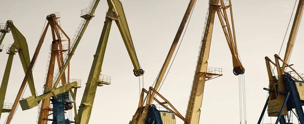 Riga, Letonya 'daki modern kömür terminali. Vinçler yakın plan. Baltık Denizi. Nakliye, lojistik, küresel iletişim, ekonomi, iş, endüstri, tedarik, özel ekipman. Şehir manzarası