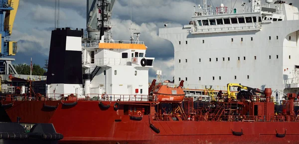 Kargo gemileri iskele terminaline yükleniyor. Vinçler arka planda. Baltık Denizi. Bunkering, akaryakıt ve enerji üretimi, arz, teknoloji, lojistik, hizmet, sanayi, ticaret