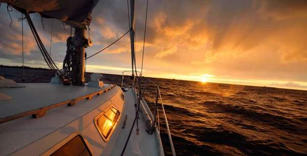 日落时 白色游艇在开阔的海面上航行 从甲板到船头的景色 史诗般的云雾 暴风雨过后 天空戏剧化 金光闪闪 休闲活动 — 图库照片