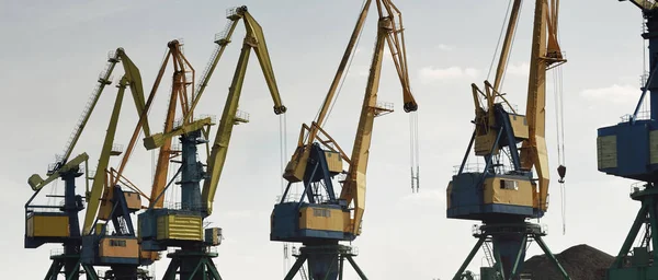 Riga, Letonya 'daki modern kömür terminali. Vinçler yakın plan. Baltık Denizi. Nakliye, lojistik, küresel iletişim, ekonomi, iş, endüstri, tedarik, özel ekipman. Şehir manzarası