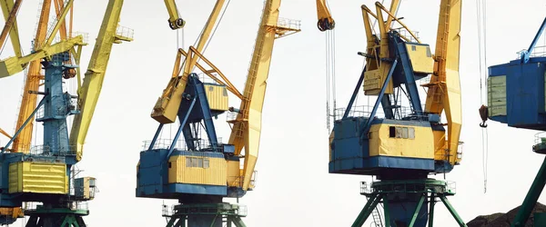 Riga, Letonya 'daki modern kömür terminali. Vinçler yakın plan. Baltık Denizi. Nakliye, lojistik, küresel iletişim, ekonomi, iş, endüstri, tedarik, özel ekipman. Şehir manzarası