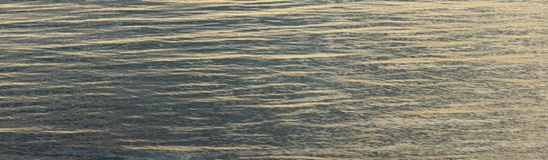 Gün batımında Baltık kıyıları (kum tepeleri). Açık mavi gökyüzü ve altın güneş ışığı, durgun sulardaki yansımalar. Soyut doğal desen, doku, arkaplan, deniz manzarası, konsept görüntü, grafik kaynaklar